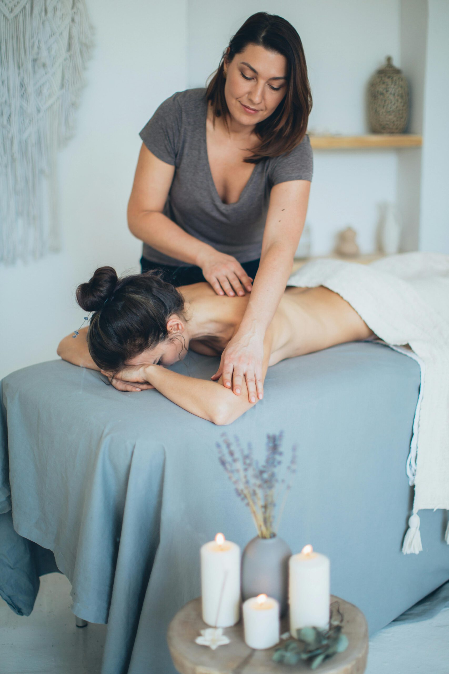 Frau massiert Frau auf Massageliege